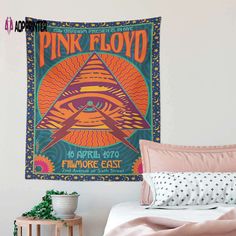 a pink floyd poster hanging on the wall above a bed