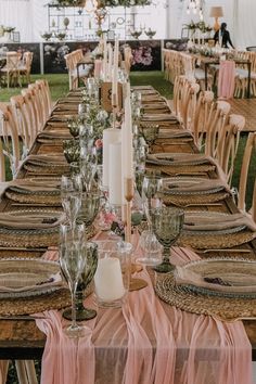 a long table set with place settings and candles