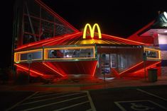 a mcdonald's restaurant lit up at night with neon lights