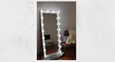 a mirror that is sitting on top of a table in front of a wall with lights