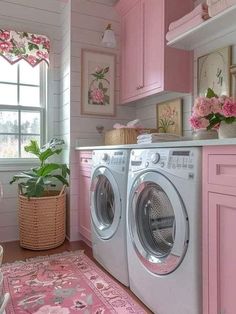 a washer and dryer in a small room with pink decor on the walls