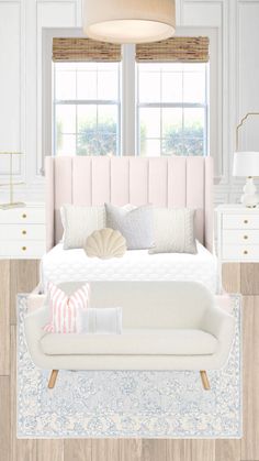 a white bed sitting next to two windows in a room with wooden floors and furniture