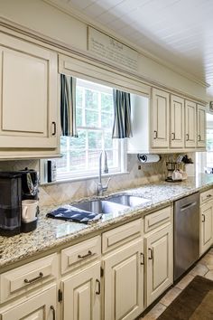 a kitchen with white cabinets and granite counter tops