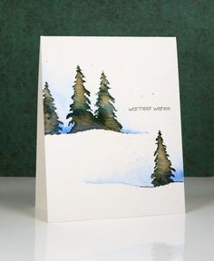 a white card with trees on it and the words warmest wishes written in black ink