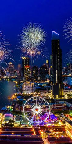 fireworks are lit up in the night sky over a city