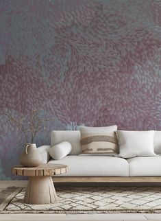 a white couch sitting on top of a wooden table in front of a purple wall