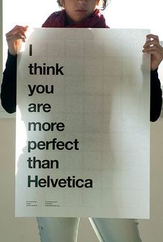 a woman holding up a sign that says i think you are more perfect than helvetica