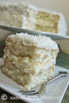 a close up of a slice of cake on a plate with a fork in front of it