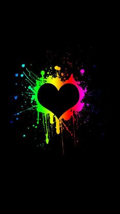 a black background with paint splattered on it and a heart shaped object in the center