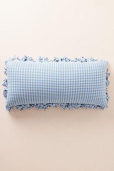 a blue and white checkered pillow on a beige wall