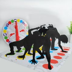 paper cut out of people dancing in front of a table with a clock on it