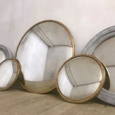 three mirrors sitting on the floor next to each other in front of a white wall