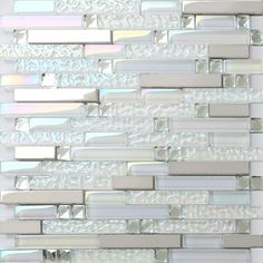 a glass tile wall with white and silver tiles on the bottom half, in an irregular pattern