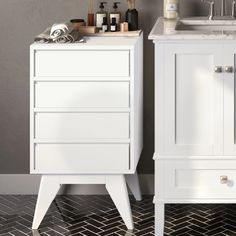 a white bathroom vanity next to a sink