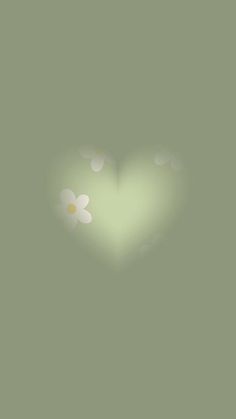 a green heart with white flowers in the middle and light shining on it's side
