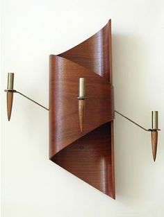 a wall mounted clock with two lights attached to it's sides and an upside down pendulum