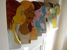 a group of women's faces are on the wall