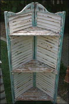 an old white painted wooden shelf in the grass