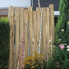 a wooden fence with plants and flowers in it