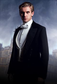 a man in a tuxedo and bow tie is posing for a photo against a dark background