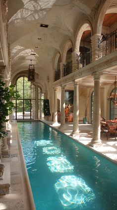 a large indoor swimming pool in the middle of a room with columns and arches on both sides