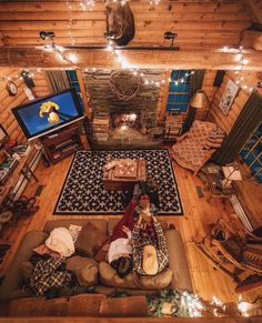 an aerial view of a living room with christmas lights on the ceiling and people sitting on couches