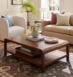 a living room with two couches, a coffee table and a rug on the floor