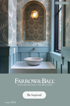 a bathroom with blue and white wallpaper and a bowl sink in front of the mirror