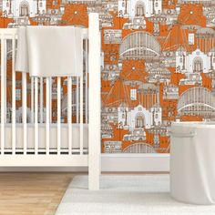 an orange and white wallpaper in a baby's room with a crib