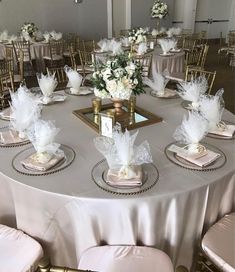 the table is set with white flowers and place settings for guests to sit down at