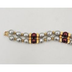 This is part of Chairish’s Costume Jewelry assortment.  Goldtone grey faux-baroque pearls with red beads and goldtone spacer beads bracelet with fold over clasp. Marked "Napier." Measures: 7 3/4 inches long by 15/16 inches wide. Pearls: 0.44 inches across by 1/2 an inch. Condition: Very good; minor wear to goldtone.  From Napier's 1985 Worldly Temptations collection.  Please reference the measurements noted in the description above for the best approximate dimensions. Please reach out to the sel Beaded Bracelets, Red Beads, Red Bead, Beads Bracelet, Baroque Pearls, Spacer Beads, Costume Jewelry, Gold Tones, Bracelet