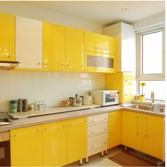 a kitchen with yellow cabinets and stainless steel appliances