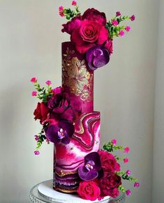 a purple and pink cake with flowers on top