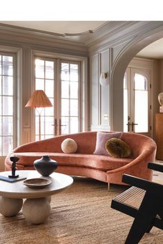 a living room filled with lots of furniture next to large window covered in sunlight pouring through the windows