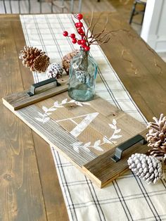 a wooden table topped with pine cones and other decorations