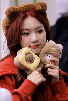 a woman with red hair holding two stuffed animals