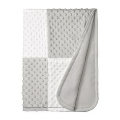 a white and grey blanket with dots on it