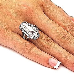 a woman's hand wearing a silver ring with a crab on the middle of it