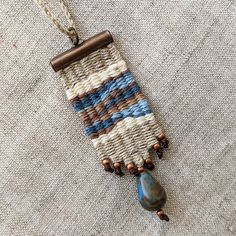 This Textile Necklace is a handwoven mini tapestry made by using natural linen and cotton thread with 1 cm glass bead. I am in love with linen, its elegant simplicity. And I want you to feel the texture of linen and enjoy its natural color. The necklace in grey and blue was inspired by the stormy sea. These woven products are a combination of old traditions with a modern vision.  * Width: 2 cm (0,8 inch) Length: 5,5 cm (2,2 inch)  * Closure: Makrame slide lock (so you can easily change the length of the necklace) * Color: Gray, Blue More about woven bracelet in the last photos: https://www.etsy.com/listing/1531758560/linen-handwoven-bracelet-minimalist?click_key=e6e3fd7713f220d7aaeac260a5b997ac02e0af8b%3A1531758560&click_sum=df540049&ref=shop_home_active_27&pro=1&frs=1 More of my woven nec Mini Weaving, Weaving Loom Diy, Small Tapestry, Weaving Loom Projects, Fiber Art Jewelry, Textile Necklace, School Jewelry, Woven Necklace, Woven Tapestry