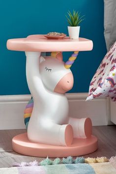 a pink unicorn table with a potted plant sitting on it's head and legs