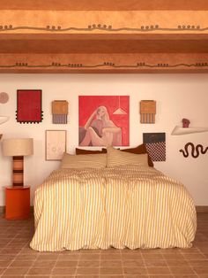 a bed sitting in a bedroom next to a lamp and pictures on the wall above it