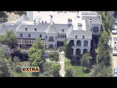 an aerial view of a large house with cars parked in the driveway