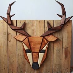 a wooden deer head mounted to the side of a fence