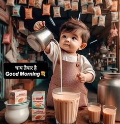 a baby in an apron pouring milk into a blender on top of a table