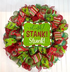 a green and red christmas wreath with the words stak stuff on it's side