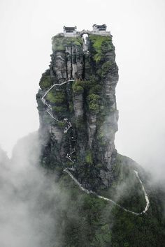 an image of a mountain with stairs going up to the top and clouds around it