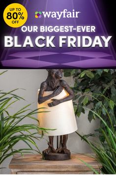 a black friday sale sign with a lamp and potted plants in the background for wayfair