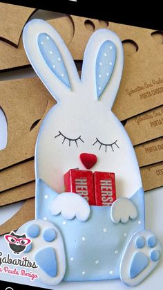 a close up of a card with a bunny holding two blocks of red and white