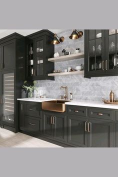 a kitchen with black cabinets and marble counter tops, gold faucets and brass sinks