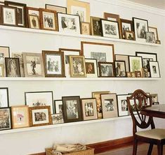 a wall full of framed photos and pictures on it's sides, along with a dining room table